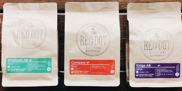Three bags of coffee laying face up on a table